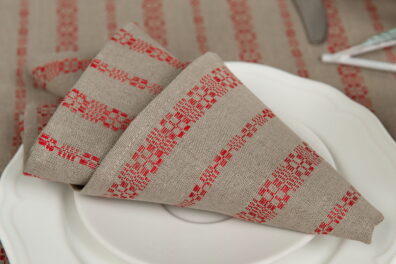 Serviette beige de lin coton en rayures rouges ornementales.
