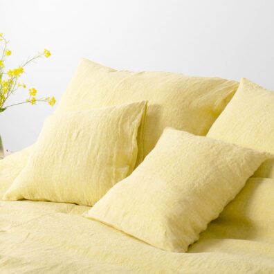 Housse de coussin de lin lavé en couleur jaune.