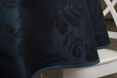 Nappe ronde ovale metis de lin coton en couleur bleu foncé avec des fleurs grandes, décorée d’un bord délicat en couleur bleu uni.