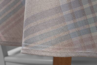 Nappe ronde ovale metis de lin coton beige en rayures roses, bleu gris, vertes, décorée d’un bord délicat en couleur beige uni.
