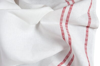 Tissu blanc cassé de lin avec des bandes rouges des deux côtés.