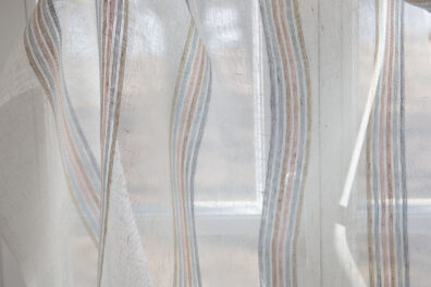 Tissu 100% lin transparent blanc cassé en rayures multicolores pasteles - verts, roses, beiges, bleus et jaunes.