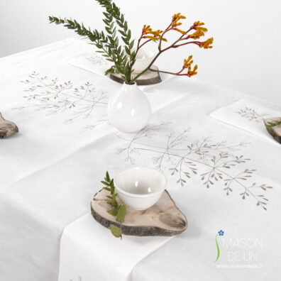 Nappe de lin blanc cassé avec de broderie élégante au milieu de la nappe.