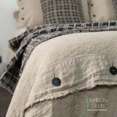 Linge de lit de lin lave avec des boutons noirs en bas.