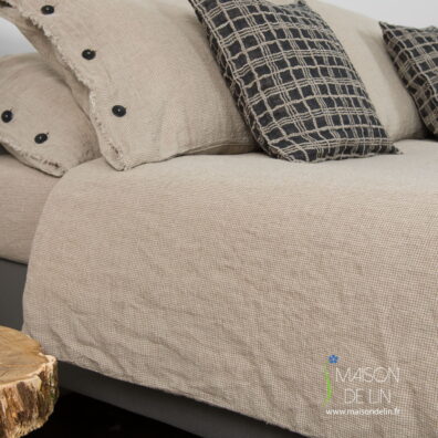 Housse de couette de lin a carreaux beige et blanc lavé, avec de boutons en bas.