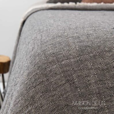 Dessus de lit gris anthracite en lin avec des franges.