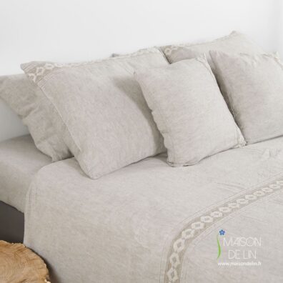 Linge de lit beige avec des dentelles.
