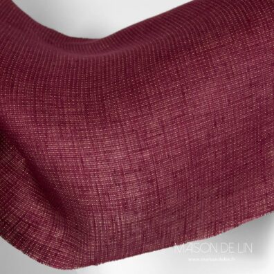Tissu lin bordeaux avec fils de lurex en couleur d`or.