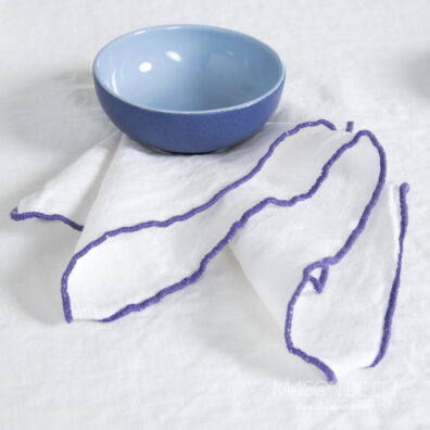 Serviette lin lavé en couleur blanc cassé en babylock violet.